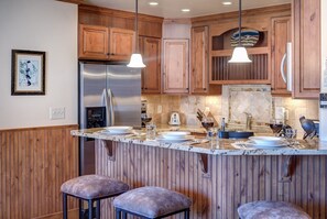 View of the kitchen from behind the breakfast counter, showing off the fridge.