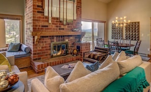 Living Room featuring brick feature fire place. Dining room and comfortable couches.