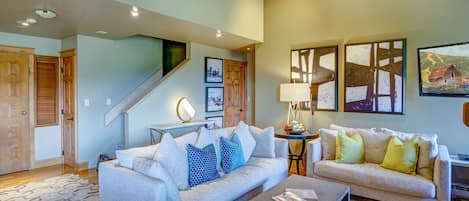 Living Room with two white couches with decorative pillows. Stone coffee table.