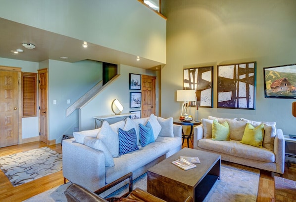 Living Room with two white couches with decorative pillows. Stone coffee table.