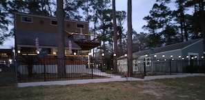 Home in the evening with lights around the fence and around the 2 decks 