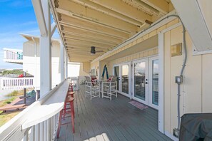 This upstairs balcony overlooks the famous Destin Harbor, a popular tourist destination known for its white sand beaches, emerald green waters, and colorful sunsets. It's a great place to relax and enjoy the view, especially at sunset.