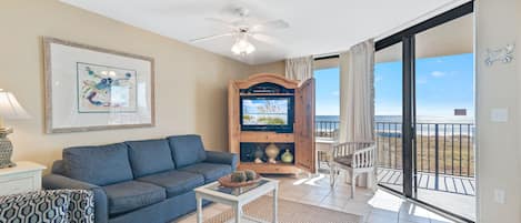Spacious Living Room offers Comfortable Seating, Beachfront Views and Balcony Access