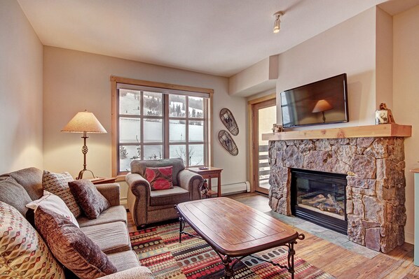 Cozy living room area with fireplace, patio, and lots of natural light.