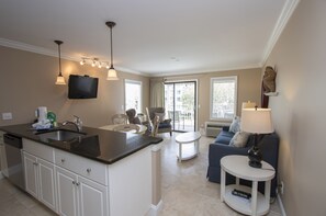 View of upgraded Kitchen/Living Room in Oceanview villa. - The newly renovated Kitchen / Dining Area features all stainless appliances, granite counters and dining bar having seating for four, and tile flooring throughout.