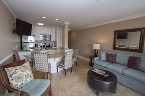 Living Room/Dining and Kitchen Area - The Living Room Area has sliding door access to the oceanside view from the balcony. Upscale 
Furnishings and a wall mounted flat screen television complete the space.