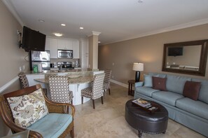 The Living Room - The Living Room Area has sliding door access to the Pool/Beachfront view Balcony. Upscale 
Furnishings and a wall mounted flat screen television complete the space.