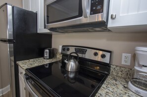 Kitchen - The newly renovated Kitchen / Dining Area features all stainless appliances, granite counters and dining bar having seating for four, and tile flooring throughout.