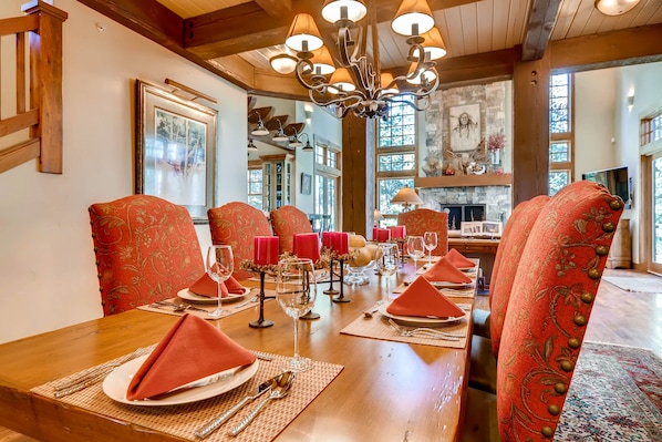 Stunning dining room with solid wood table, high back chairs, opening to the impressive living area