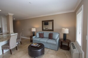 Living Room - Living room offers comfy sofa bed, wall mounted smart flat screen T.V. and sliding door to balcony with amazing Beachfront view and Palm trees.