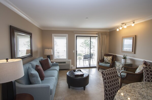 Living Room - Living room offers comfy sofa bed, wall mounted smart flat screen T.V. and sliding door to balcony with amazing Beachfront view and Palm trees.