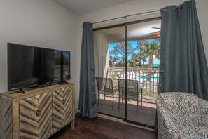 Balcony/ Ocean Front pool view - Living room offers comfy sofa bed, wall mounted smart flat screen T.V. and sliding door to balcony with amazing Beachfront view and Palm trees.