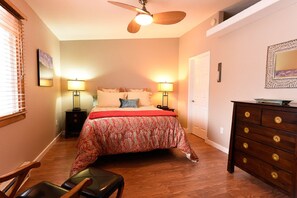 Bedroom with luxury bedding, leather chair, ceiling fan and walk-in closet. 