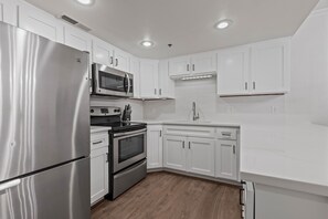 The kitchen has stainless steel appliances and white cabinets.