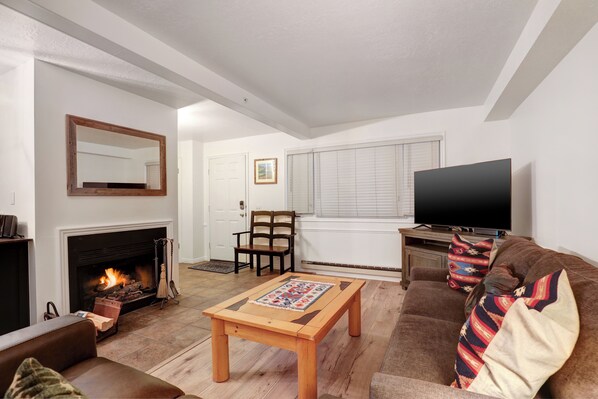 Sun Creek A7 offers a living room with wood burning fireplace, flat-screen TV and comfortable furnishings.
