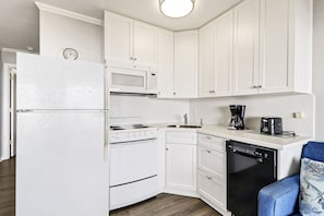 Kitchen - Bright white compact kitchen with all major appliances and regular drip coffeemaker.