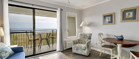 Living /dining area - Great view onto the oceanfront balcony from this newly painted villa.  New window treatments also.