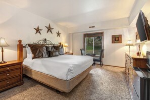 Park Station 214 has a main suite with a king size bed, stair décor on the walls, leather pillows, and solid wood bedframe.