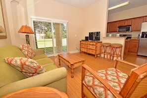 Lounge area showing patio doors and flatscreen TV and kitchen showing bar seating for two