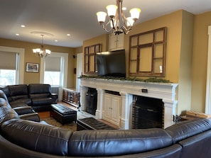 Living room has dual wood fireplaces and 65" TV with Bose surround sound.