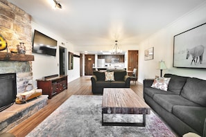 Open floor plan with hardwood floors throughout, living room in the foreground and dining and kitchen in the background