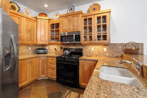 The well-equipped kitchen offers solid wood cabinets, granite counters and spacious floor plan.