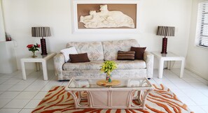The living room's main seating area. The couch is a queen-sized sofa bed