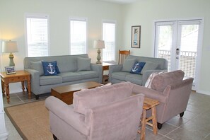 Living room opens to private porch with comfortable seating and gas grill