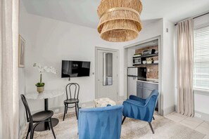 Cozy and functional space featuring a bistro for two, perfect for enjoying light meals or a morning coffee. The setup is complemented by natural light streaming in through the glass doors and elegant decor accents.