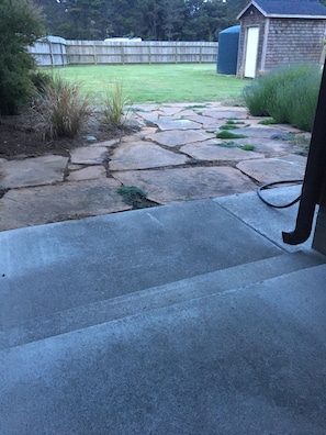 Flagstone patio next to spacious redwood deck