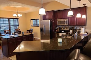Fully Equipped Kitchen with Stainless Steel Appliances. Ceramic Tile Floor.