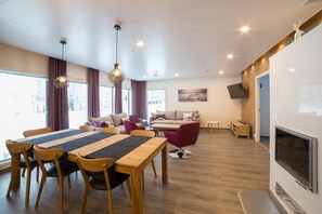 open concept living room kitchen dining area with fireplace and lake view