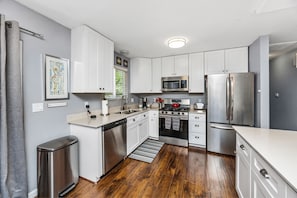 Kitchen w/ gas range, dishwasher, quartz counters, equipped to delight the cook.