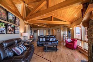 Cozy living room with reclining furniture around a stone gas log fireplace