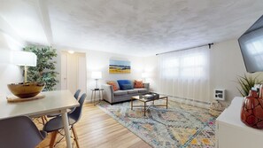 Bright living and dining area with cozy seating and decor.