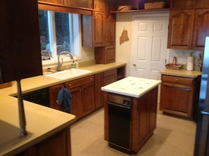 Kitchen with cherry cabinets with door to laundry room.