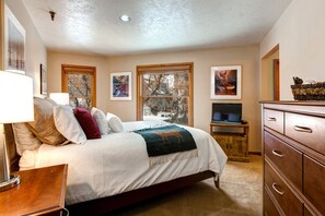 Cozy queen bed, scenic window view, sleek TV cabinet.