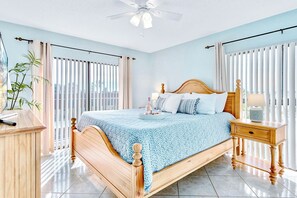 Spacious master bedroom with a plush king bed, big screen TV and soothing coastal tones