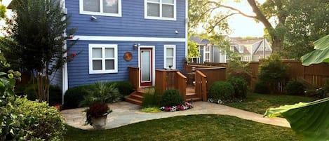 Fenced in private backyard with deck, patio, 4 burner grill, lush landscaping.