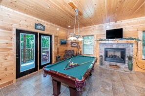 Great game room downstairs with a pool table, fireplace, TV and access to the deck