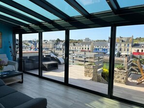 De l'intérieure de la maison, vue sur la terrasse et sur  le port