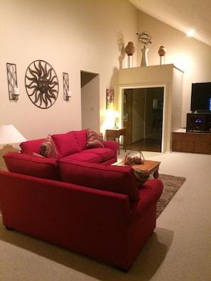 Very spacious living room with vaulted ceiling and sleeper sofa and smart TV