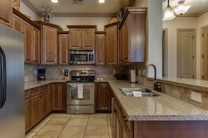 Fully stocked gourmet kitchen featuring top of the line appliance s