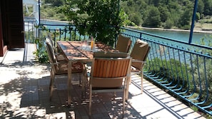 Dining area on the terrace, overlooking garden and beach.