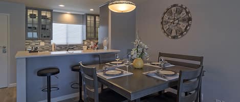 Spacious dining area seats 6 with additional seating at breakfast bar.