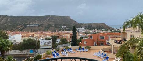 View from the balcony of the shared pool terrace with sun loungers.