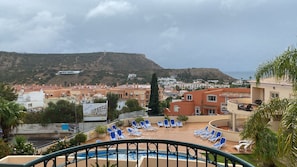 View from the balcony of the shared pool terrace with sun loungers.