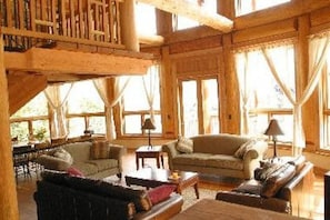 The great room with big windows and mountain views