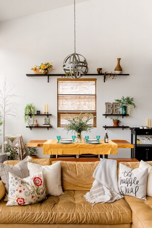 Snuggly couch and view towards table with wine barrel strip chandelier