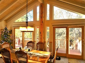 Vaulted wood ceiling dining room with Christmas Tree and back deck tree view...